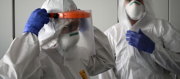 Медработники надевают свои средства индивидуальной защиты перед началом работы - Sputnik Moldova