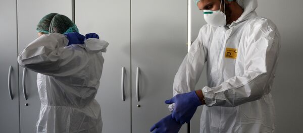 Медработники надевают свои средства индивидуальной защиты перед началом работы - Sputnik Moldova