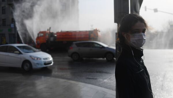 Девушка в медицинской маске стоит на переходе на Тверской улице в Москве - Sputnik Молдова