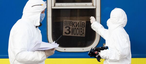 Медики в костюмах биологической защиты у специального поезда №906/905 Киев - Москва - Киев, прибывшего на железнодорожный вокзал Киева - Sputnik Молдова