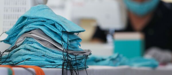 Сотрудник обувной компании делает маски для пожертвования больницам во время пандемии коронавируса  - Sputnik Moldova