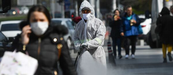 Un muncitor pulverizează dezinfectant pe trotuar - Sputnik Moldova-România