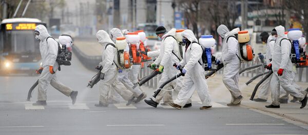 Muncitori pulverizând dezinfectant pe o stradă din București Muncitori pulverizând dezinfectant pe o stradă din București - Sputnik Moldova-România