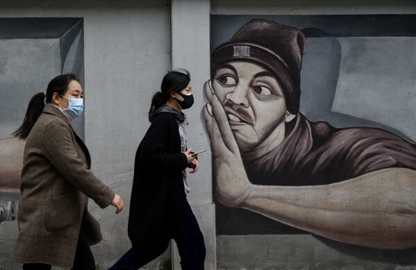 Девушки в масках напротив граффити в Ухане  - Sputnik Молдова