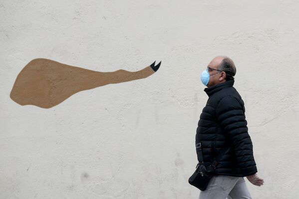 Мужчина напротив граффити с изображением иберийской ветчины в Мадриде - Sputnik Молдова