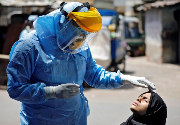 Доктор в защитном костюме тестирует девушку на коронавирус в Ахмедабаде, Индия - Sputnik Молдова