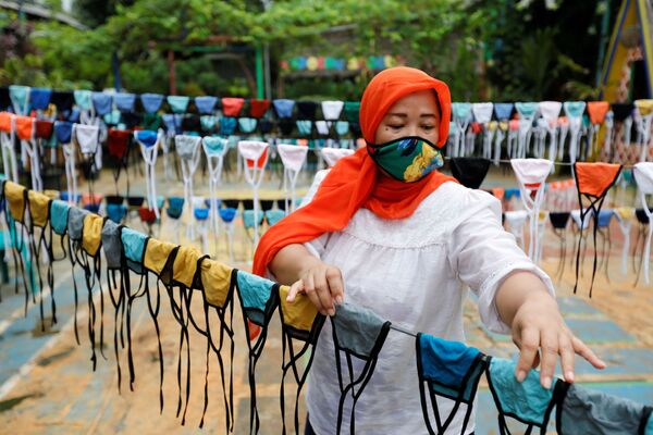 Женщина в защитной маске во время изготовления масок в Тангеранге на окраине Джакарты, Индонезия - Sputnik Молдова