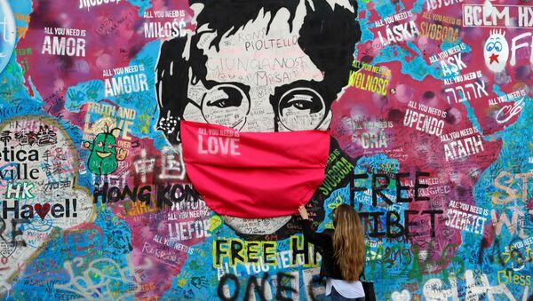  Женщина в маске у легендарной стены Джона Леннона в Праге - Sputnik Молдова