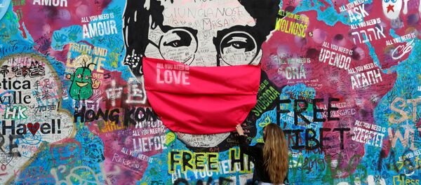 Женщина в маске у легендарной стены Джона Леннона в Праге Женщина в маске у легендарной стены Джона Леннона в Праге - Sputnik Молдова