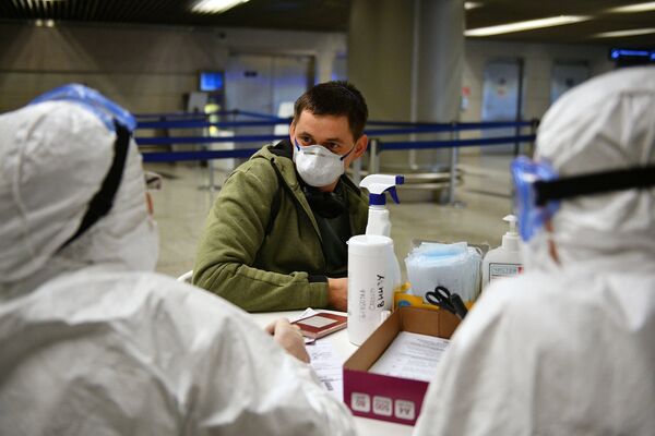 Медицинские работники во время проверки состояния пассажира в аэропорту Внуково - Sputnik Молдова