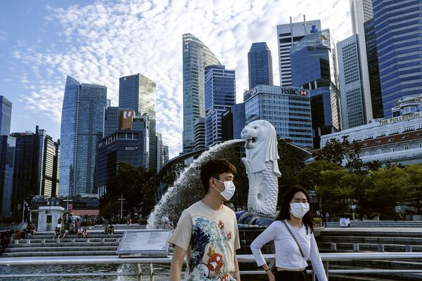 Пара в масках у статуи Мерлиона в Сингапуре - Sputnik Молдова