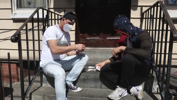 Двое мужчин в защитных масках играют в карты на крыльце дома в Бруклине, Нью-Йорк - Sputnik Moldova-România