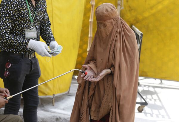 Женщина дезинфицирует руки чтобы предотвратить распространение коронавируса в Лахоре, Пакистан  - Sputnik Молдова