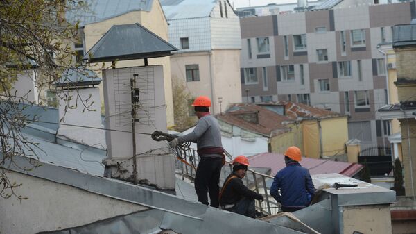 Рабочие-строители на крыше здания в Москве. - Sputnik Moldova-România