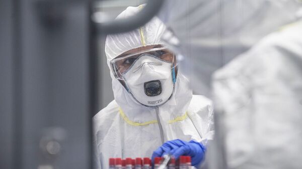 Сотрудник лаборатории проводит тесты на коронавирусную инфекцию, архивное фото.  - Sputnik Молдова