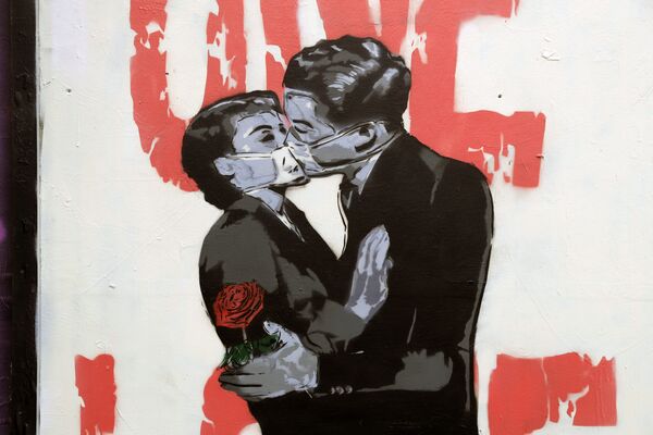 Граффити с изображением целующихся в масках влюбленных на стенде в Лондоне, Великобритания - Sputnik Молдова
