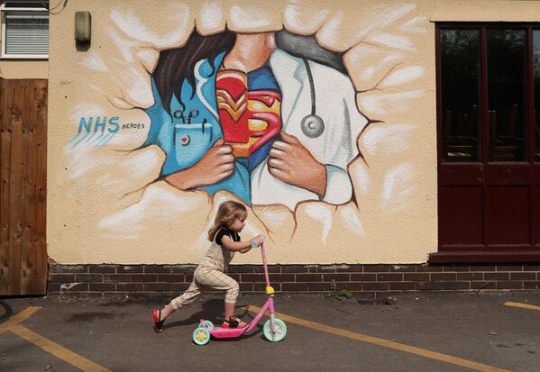 Девочка на самокате во время прогулки у граффити в Понтефракте - Sputnik Молдова