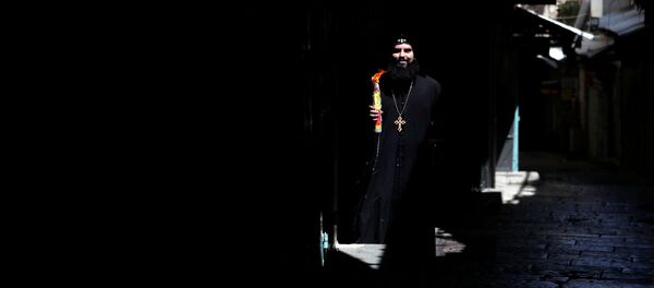 Православный христианский священнослужитель держит свечи в руках после церемонии Священного Огня рядом с Церковью Гроба Господня в Старом городе Иерусалима в разгар вспышки коронавирусной болезни Православный христианский священнослужитель держит свечи в руках после церемонии Священного Огня рядом с Церковью Гроба Господня в Старом городе Иерусалима в разгар вспышки коронавирусной болезни - Sputnik Молдова