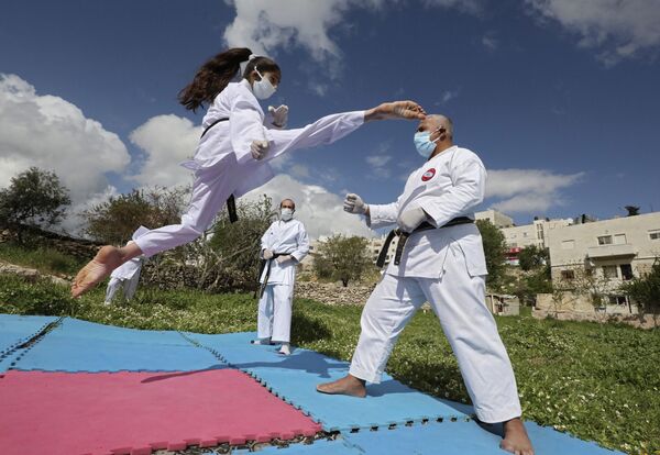 Палестинская чемпионка по карате во время тренировки со своим отцом дома в Хевроне  - Sputnik Молдова