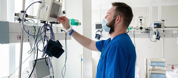Медицинский работник маске настраивает оборудование - Sputnik Moldova