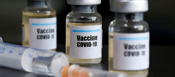 Маленькие бутылочки с наклейкой «Vaccine COVID-19» и медицинский шприц - Sputnik Moldova-România