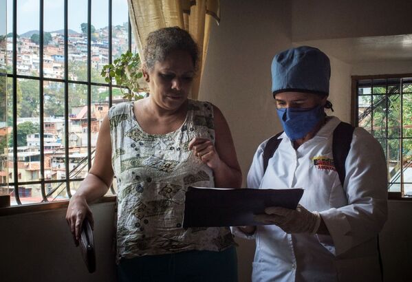Медицинский работник во время обхода жителей для выявления случаев заболевания коронавирусом в фавелах Каракаса - Sputnik Moldova-România