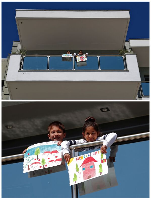 Десятилетний Василис Бекиарис и семилетняя Аггелики Бекиарис с рисунками на балконе своего дома в Салониках, Греция - Sputnik Moldova-România