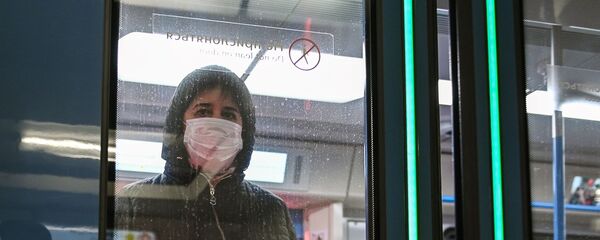 Женщина в защитной маске в вагоне поезда на станции метро Новокузнецкая в Москве - Sputnik Молдова