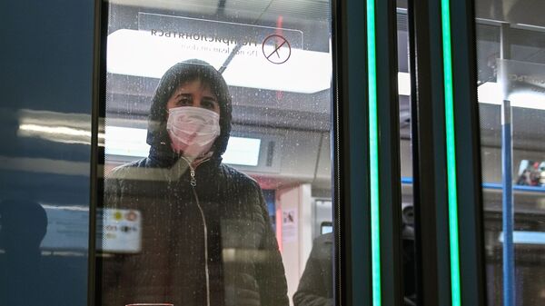 Женщина в защитной маске в вагоне поезда на станции метро Новокузнецкая в Москве - Sputnik Moldova-România