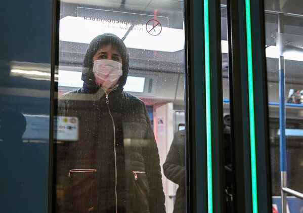 Женщина в защитной маске в вагоне поезда на станции метро Новокузнецкая в Москве - Sputnik Молдова