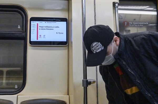 Мужчина в защитной маске в вагоне поезда Московского метрополитена - Sputnik Молдова