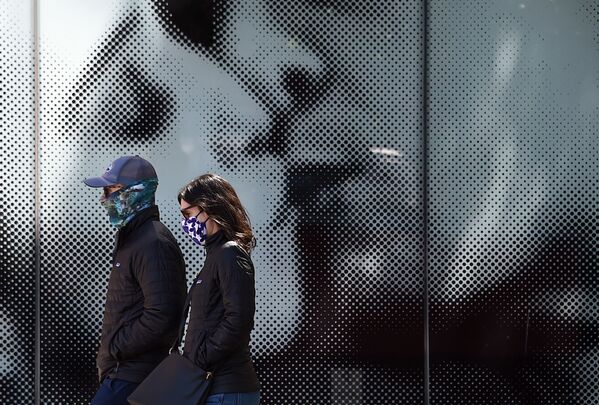 Пара в защитных масках проходит мимо афиши у кинотеатра в Вашингтоне, США - Sputnik Молдова