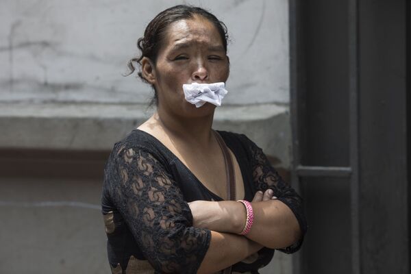 Женщина держит бумагу во рту, как альтернативу маске, в очереди бесплатный обед для бездомных в Лиме, ​​Перу - Sputnik Moldova