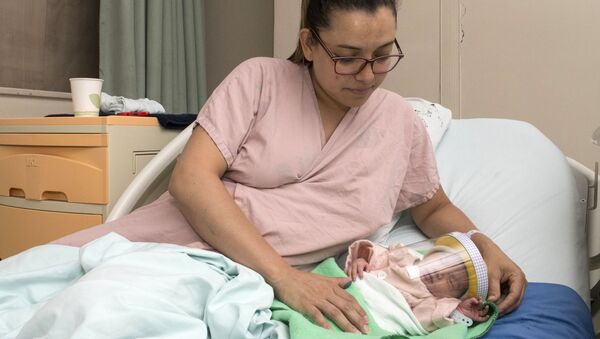 Женщина с новорожденным ребенком в защитной маске в отделении неонатологии мексиканской больницы в Сан-Хосе, Коста-Рика - Sputnik Moldova-România