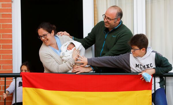 Семья из Ронды показывает соседям своего новорожденного ребенка в период пандемии коронавируса в Испании - Sputnik Moldova-România
