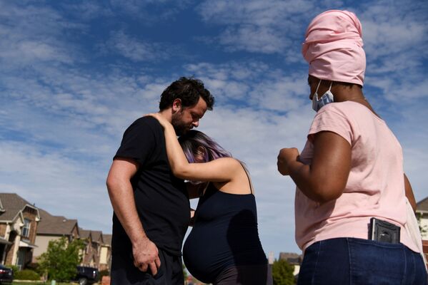 Беременная женщина испытывает схватки во время прогулки со своим партнером возле дома акушерки во время эпидемии коронавируса Форт-Уэрте, штат Техас, США - Sputnik Moldova-România
