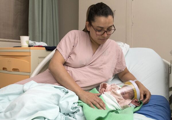 Женщина с новорожденным ребенком в защитной маске в отделении неонатологии мексиканской больницы в Сан-Хосе, Коста-Рика - Sputnik Moldova-România