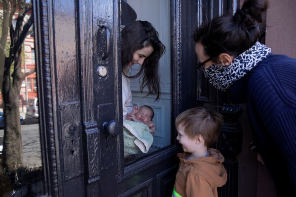 Девушка показывает своего новорожденного ребенка родственникам через стекло в Бруклинском районе Нью-Йорка, США - Sputnik Moldova-România
