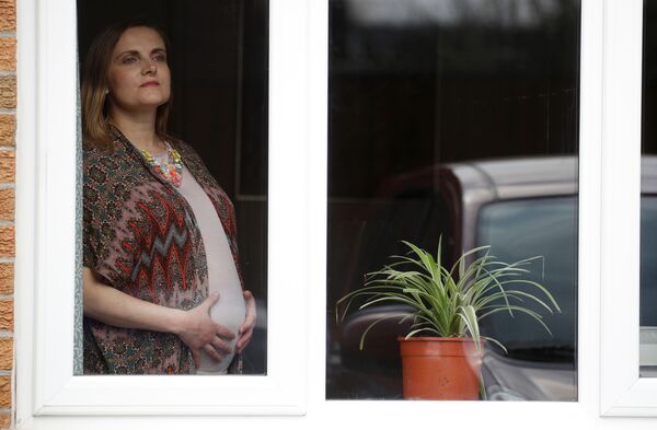 Беременная девушка в окне своей гостинной в Манчестере, Великобритания - Sputnik Moldova-România