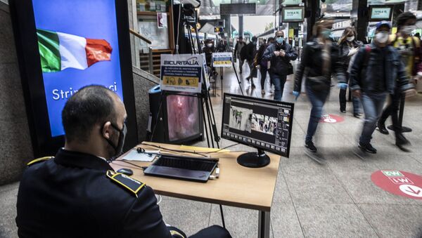 Охранник проверяет пассажиров на вокзале в Милане после этапного завершения карантина в Италии - Sputnik Moldova-România