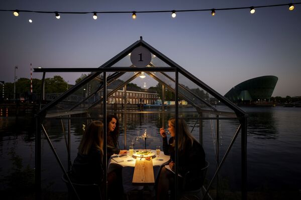 Друзья во время обеда в ресторане в формате «карантинных теплиц» в Амстердаме  - Sputnik Moldova-România