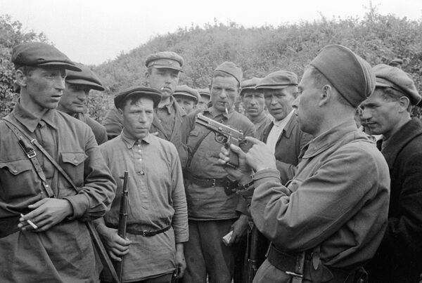 Командир партизанского отряда знакомит бойцов с оружием. Смоленская область, 1941 год - Sputnik Moldova-România