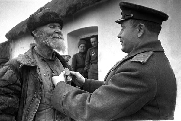Командир дивизиона награждает колхозника Помкина за подвиг. 3-ий Украинский фронт. 1945 год - Sputnik Moldova