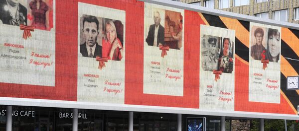 Экран с портретами участников Великой Отечественной войны, размещенный на здании кинотеатра Октябрь на Новом Арбате в рамках акции Бессмертный полк. - Sputnik Молдова