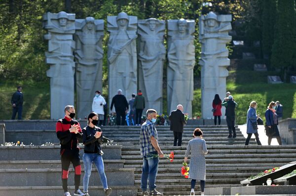 В Литве, несмотря на карантин, жители столицы отправились к мемориалам павших советских воинов, чтобы возложить цветы в честь их подвига  - Sputnik Молдова