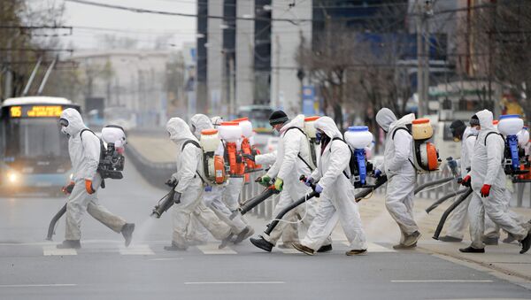 Muncitori pulverizând dezinfectant pe o stradă din București - Sputnik Moldova