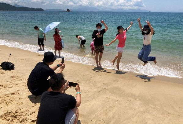Люди в масках на пляже во время фотогарфирования в Китае  - Sputnik Молдова
