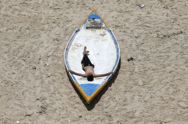 Палестинский юноша во время отдыха на пляже в Газе  - Sputnik Молдова