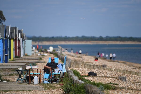Мужчина во время отдыха на пляже в Южной Англии  - Sputnik Moldova-România