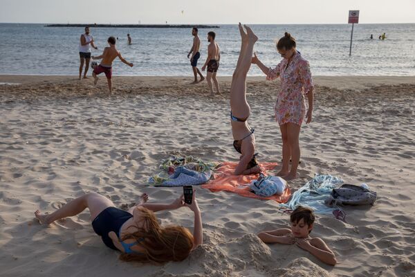 Люди во время отдыха на пляже в Тель-Авиве  - Sputnik Moldova-România